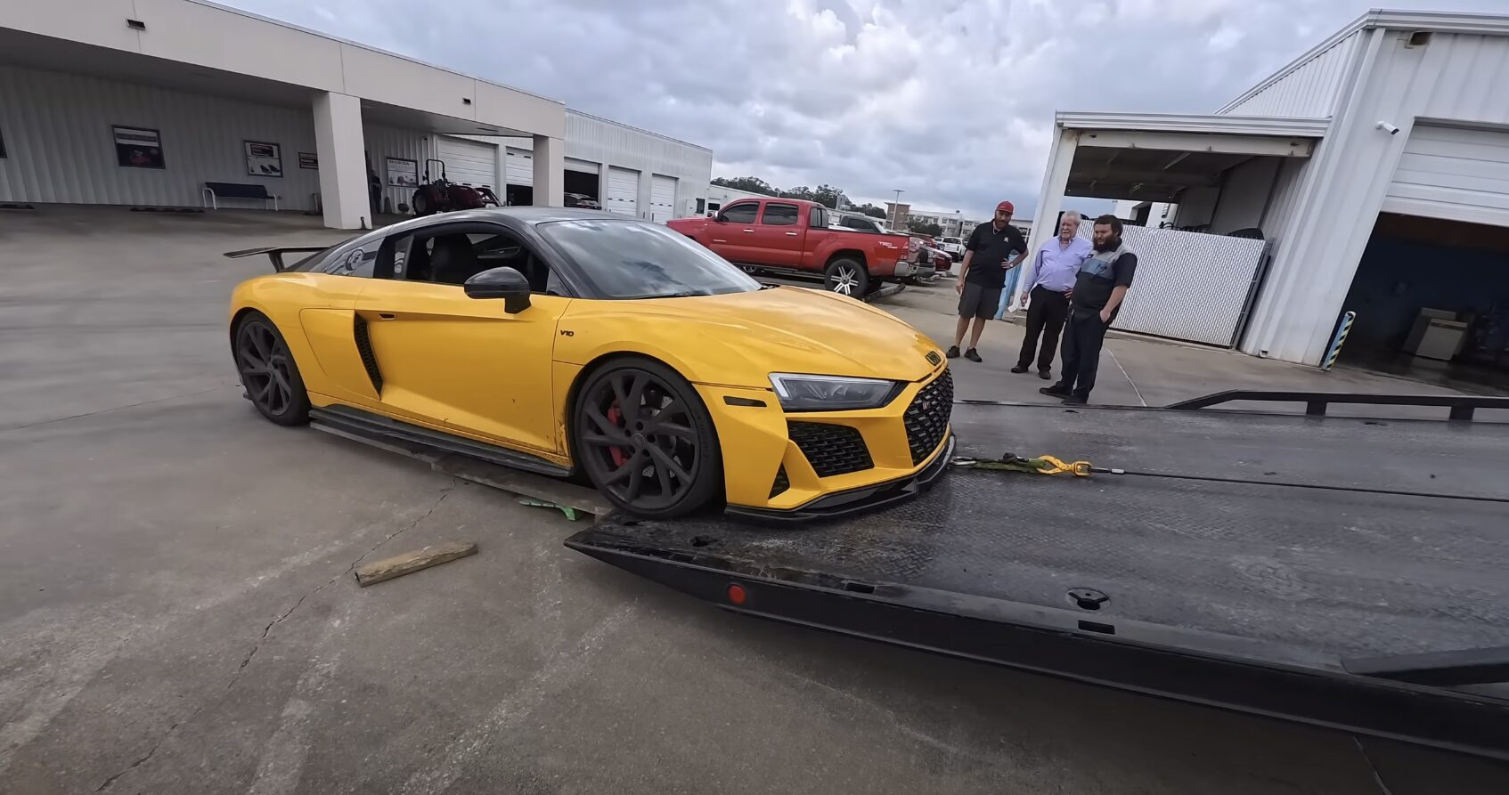 Luxury and Sports Car Towing - Professional Flatbed Service Yellow Audi R8 sports car being loaded onto professional tow truck flatbed